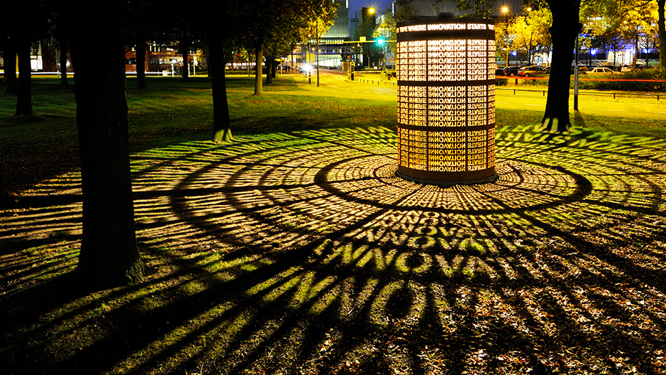 Light object 'Transformatie', a light art design on the TU/e campus, was created by Michel Suk for GLOW 2012. The text 'Where Innovation Starts' is reflected on the grass.