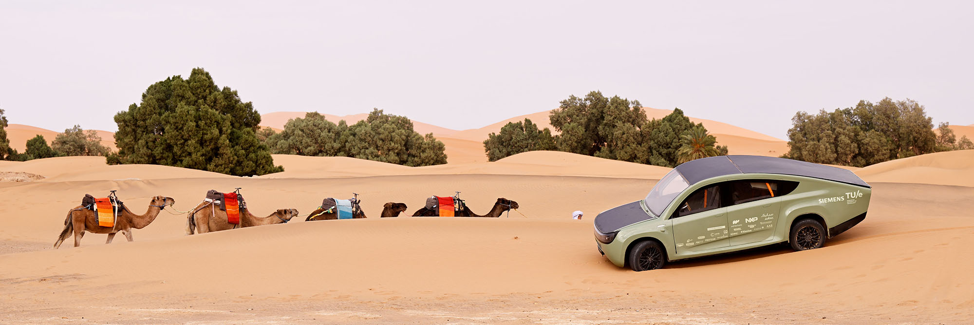 Off-road solar-powered car Stella Terra, developed by Solar Team Eindhoven, shown in the Morrocan desert with camels